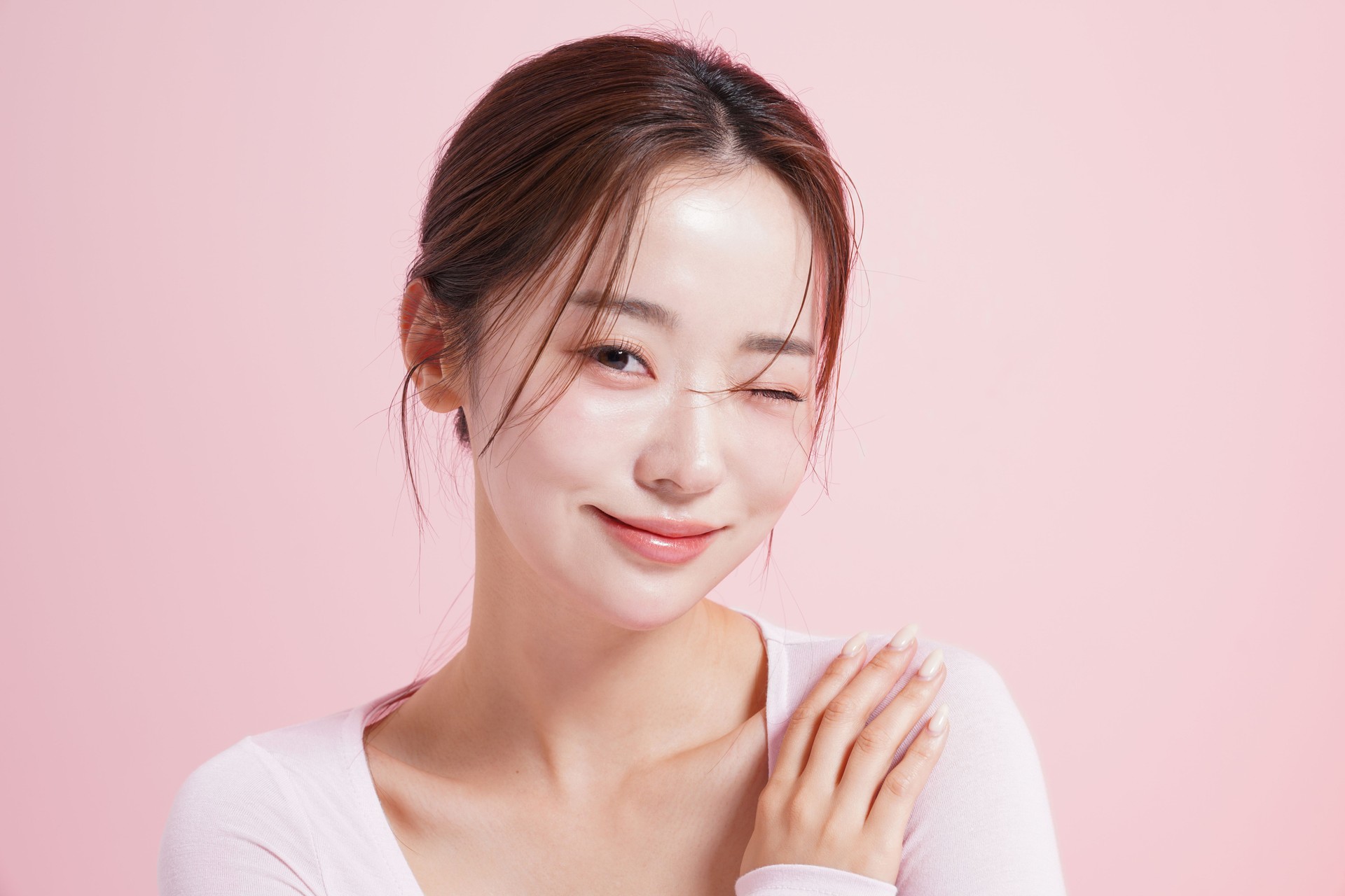 Catchy beauty portrait of a young woman shot against a pink background